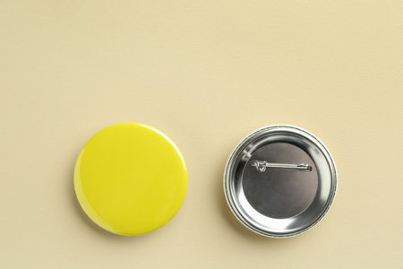 Button badges on beige background, flat lay. Mockup for design