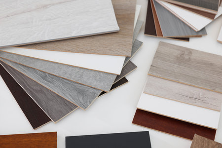 Different samples of wooden flooring on white table