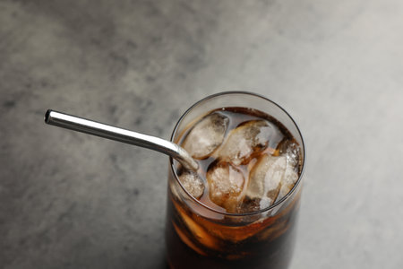 Tasty refreshing drink with straw in glass on gray table, closeupの写真素材