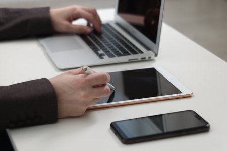 Businessman using different devices at white table indoors, closeup. Modern technologyの写真素材