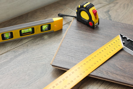Measuring tools and laminate flooring pieces on wooden surface, closeupの写真素材