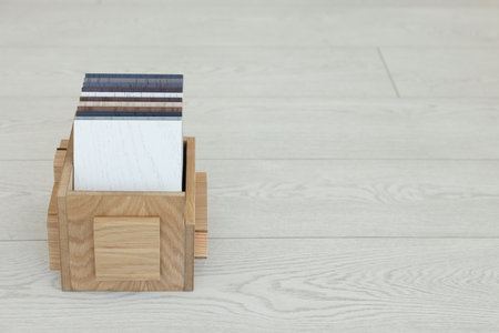 Different samples of wooden flooring in crate indoors, space for textの写真素材