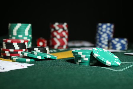 Poker game. Casino chips on green table, closeup