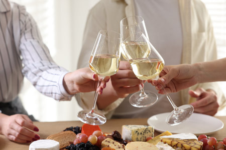 People clinking glasses of wine at served table, closeupの写真素材