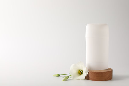 Solid deodorant and beautiful eustoma flower on white background, space for textの写真素材