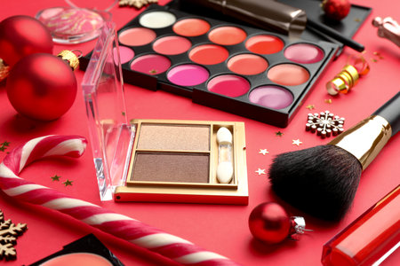 Makeup products and Christmas decor on red background, closeupの写真素材