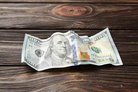 One crumpled dollar banknote on wooden table, closeupの写真素材