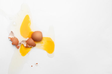 Raw broken egg on white background, top view