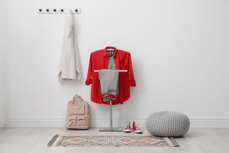 Coat rack, pouf, backpack, clothes and shoes in hallway