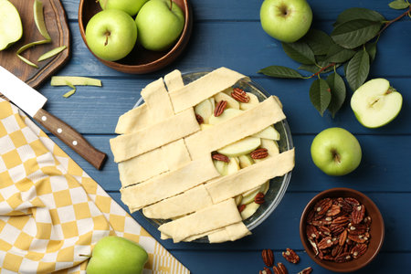 Flat lay composition with raw homemade apple pie and ingredients on blue wooden tableの写真素材