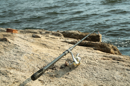 One fishing rod on shore near lake outdoorsの写真素材