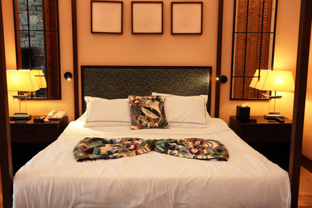 Comfortable large bed in stylish hotel roomの写真素材