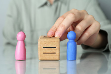 Gender equality concept. Woman with male and female figures at gray table, closeup