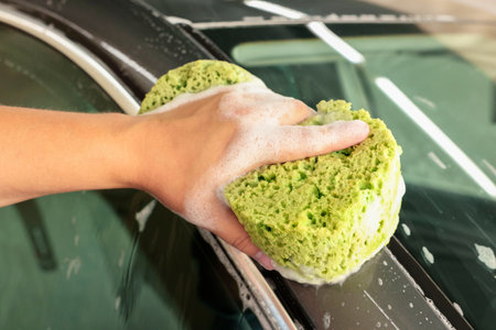 Man washing auto with sponge at car wash, closeupの写真素材