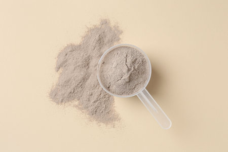 Protein powder and scoop on beige background, top viewの写真素材