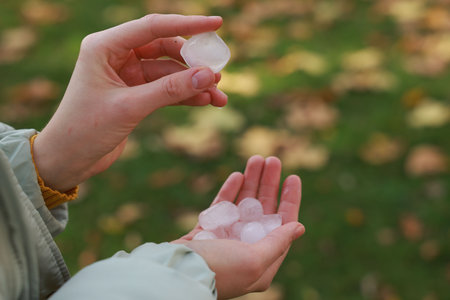 Woman holding hail grains after thunderstorm outdoors, closeupの写真素材