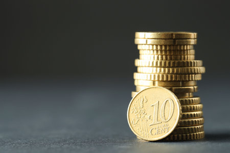 Stacked euro coins on gray table, space for text