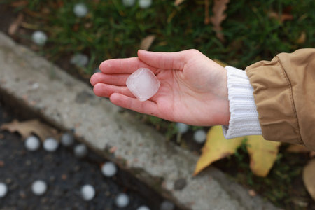 Woman holding hail grain after thunderstorm outdoors, closeupの写真素材