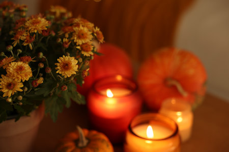 Burning candles, flowers and pumpkins indoors, closeup. Autumn atmosphereの写真素材