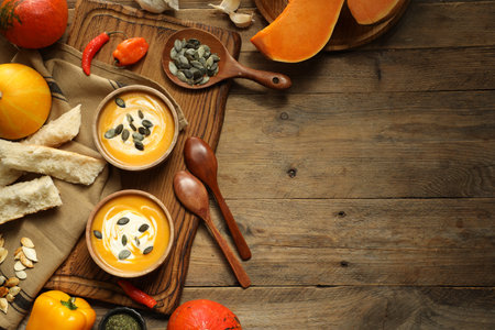 Delicious pumpkin soup served on wooden table, top view. Space for textの写真素材