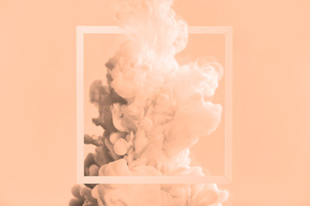 Splash of ink and frame on peach fuzz color background