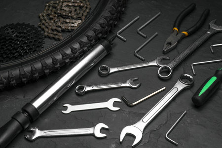 Parts of bicycles and tools on black tableの写真素材