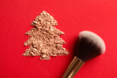 Christmas tree made of face powder and brush on red background, top viewの写真素材
