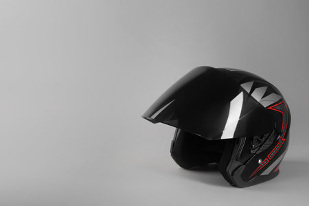 Motorcycle helmet with visor on light gray background, space for textの写真素材