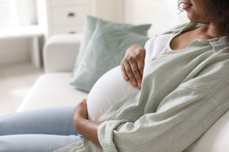 Pregnant woman on sofa at home, closeupの写真素材