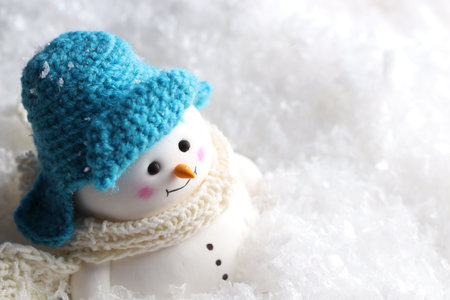 Cute decorative snowman on artificial snow, closeup. Space for textの写真素材
