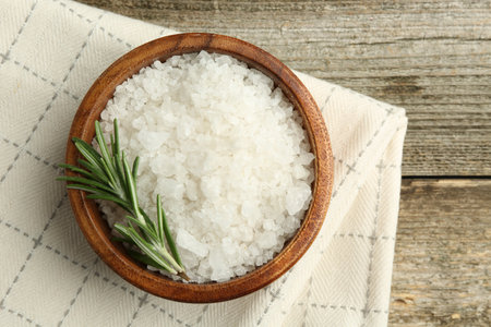Sea salt in bowl and rosemary on wooden table, top viewの写真素材