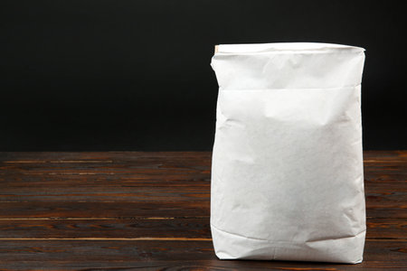 Bag of cement powder on wooden table, space for text. Building materialの写真素材