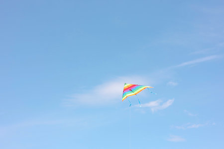 One colorful kite flying in blue skyの写真素材