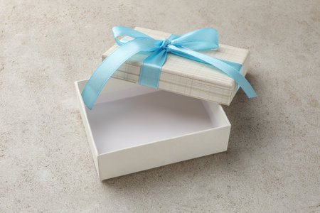 Empty gift box with bow on light gray table