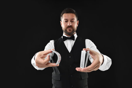 Professional croupier shuffling cards on black backgroundの写真素材