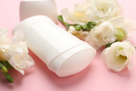 Solid deodorant and beautiful eustoma flowers on pink background, closeupの写真素材