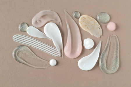 Smears of different cosmetic products on gray background, flat layの写真素材