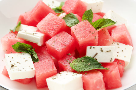 Delicious watermelon salad with mint and feta cheese in bowl on table, closeupの写真素材