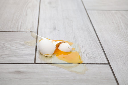 Raw broken egg on light wooden floorの写真素材