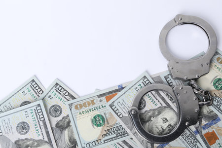 Corruption concept. Handcuffs and dollar banknotes on white background, top viewの写真素材