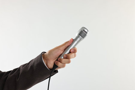 Man with microphone on light background, closeupの写真素材