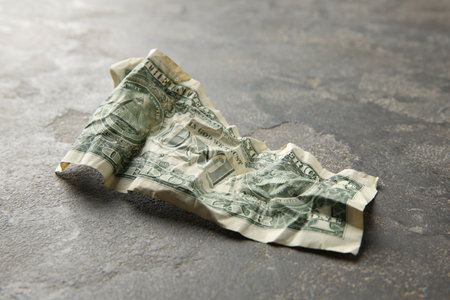 One crumpled dollar banknote on gray table, closeupの写真素材