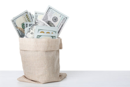Dollar banknotes in bag on table against white background, space for textの写真素材