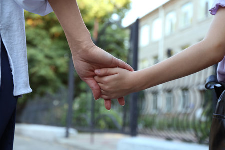 Mother and daughter holding hands outdoors, closeupの写真素材