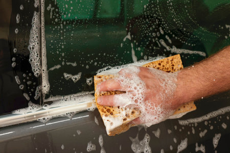 Man washing auto with sponge at car wash, closeupの写真素材