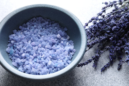 Natural sea salt and lavender flowers on gray table, closeupの写真素材