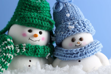Cute decorative snowmen against light blue background, closeupの写真素材