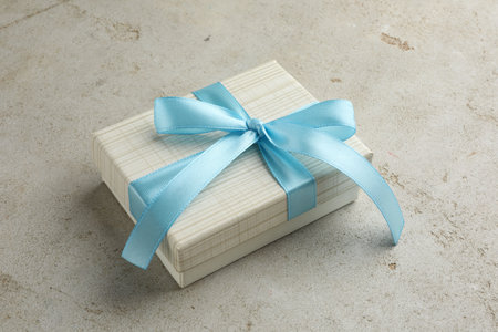 Beautiful gift box with bow on light gray table