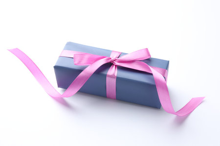 Beautiful gift box with pink bow isolated on whiteの写真素材