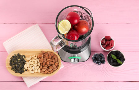 Blender and fresh ingredients on pink wooden table, top viewの写真素材